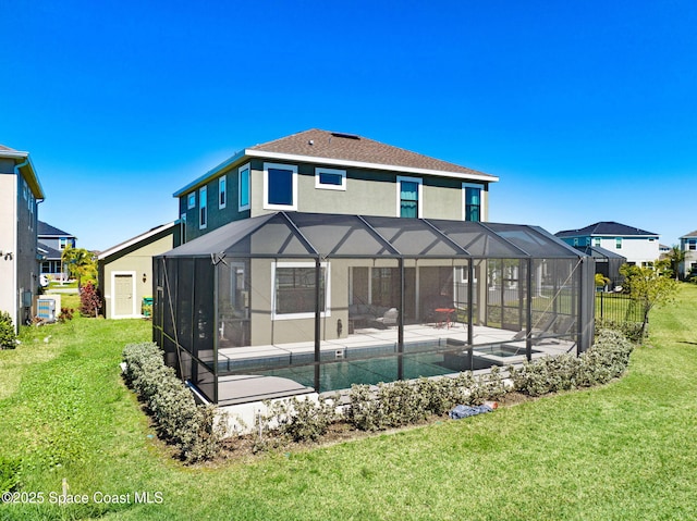 back of house featuring glass enclosure, a yard, a patio, and stucco siding