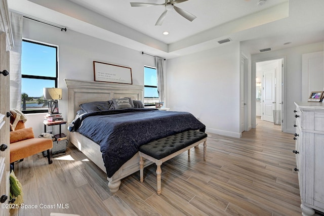 bedroom with light wood-style floors, multiple windows, and visible vents