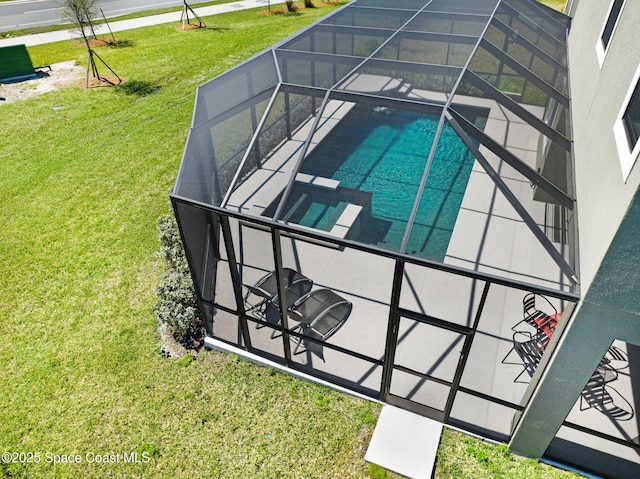 view of swimming pool featuring a lanai, a patio area, a pool with connected hot tub, and a yard