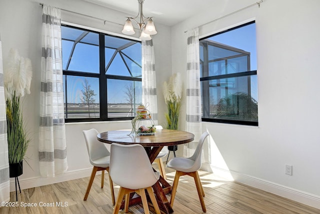 dining area with an inviting chandelier, baseboards, and wood finished floors