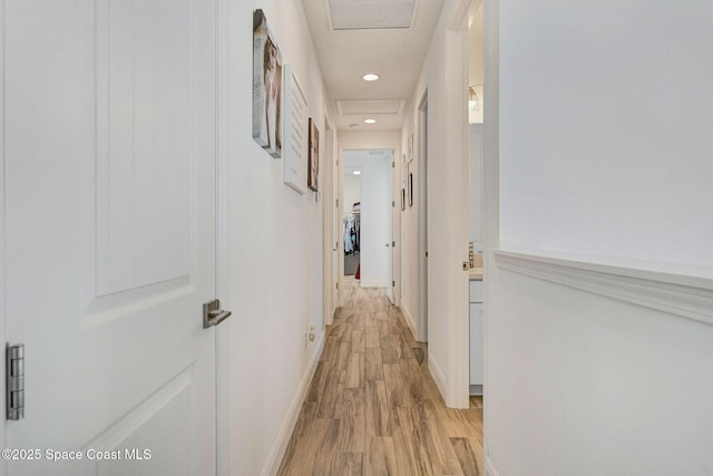 hallway featuring attic access, visible vents, baseboards, light wood-type flooring, and recessed lighting