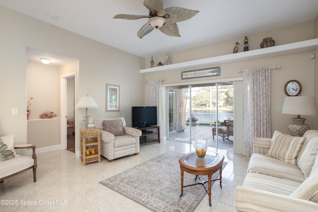 living room with light tile patterned flooring, a ceiling fan, and baseboards