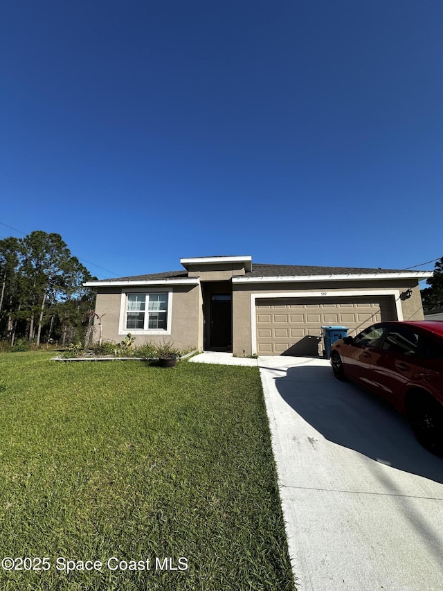 view of front of home featuring a garage, driveway, a front lawn, and stucco siding