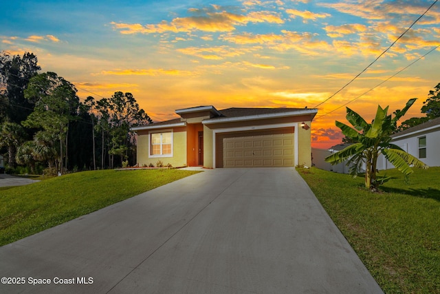 view of front of home with concrete driveway, a front lawn, an attached garage, and stucco siding