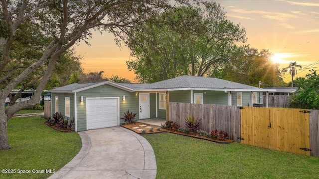 ranch-style home featuring concrete driveway, a yard, an attached garage, and fence