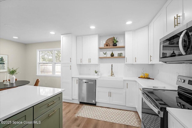 kitchen with white cabinetry, stainless steel appliances, and light countertops