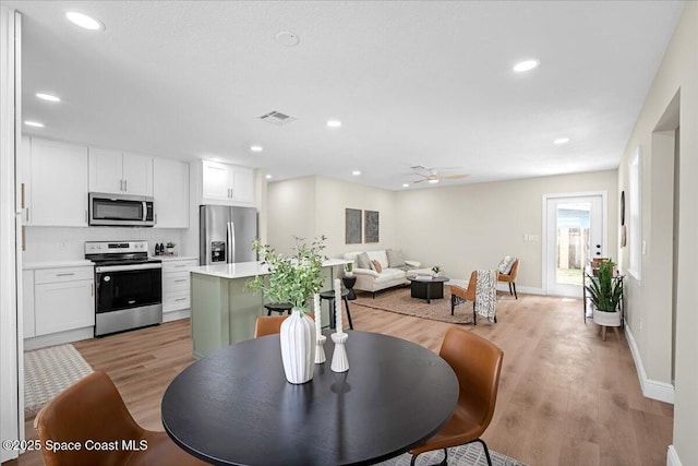 dining room with baseboards, visible vents, ceiling fan, light wood-type flooring, and recessed lighting