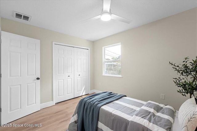 bedroom with a closet, visible vents, light wood-style flooring, a ceiling fan, and baseboards