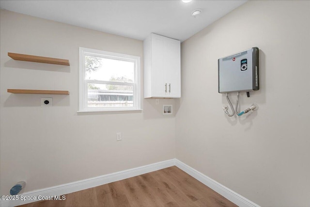 laundry room with hookup for a washing machine, cabinet space, hookup for an electric dryer, wood finished floors, and baseboards