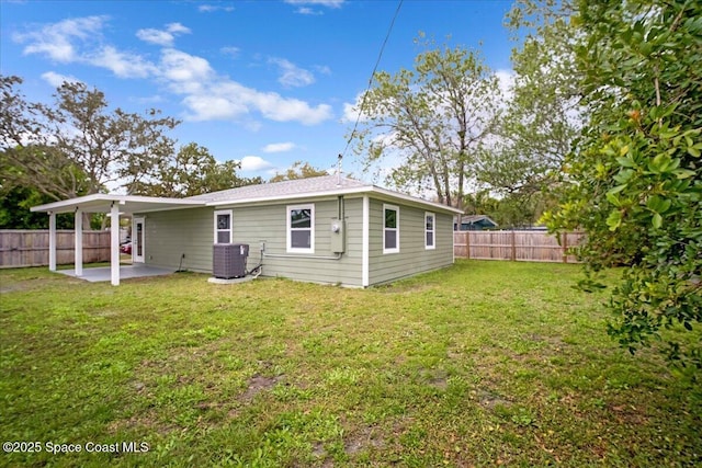 back of property with a yard, a fenced backyard, a patio, and central AC unit