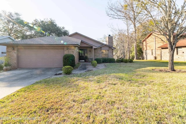 mid-century modern home featuring concrete driveway, a chimney, an attached garage, a front lawn, and brick siding