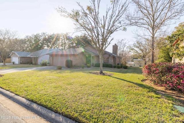 view of front of property with a garage, driveway, a front lawn, and a chimney