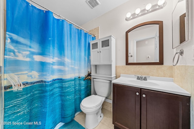 full bath with tile patterned flooring, toilet, vanity, visible vents, and tile walls