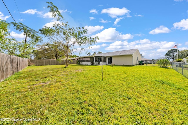 view of yard with a sunroom and a fenced backyard