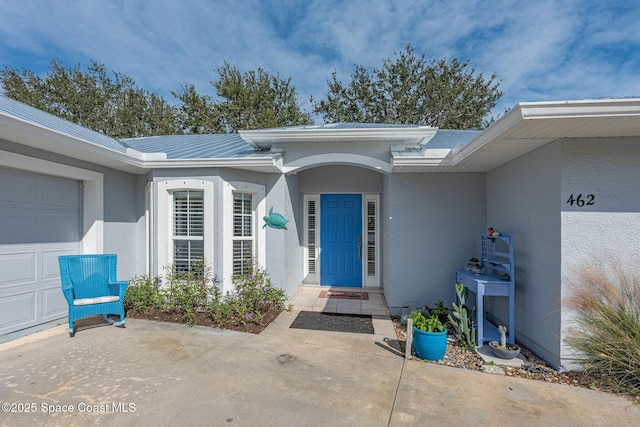 property entrance featuring a garage and stucco siding