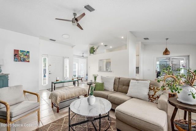 living room with lofted ceiling, a healthy amount of sunlight, visible vents, and light tile patterned floors