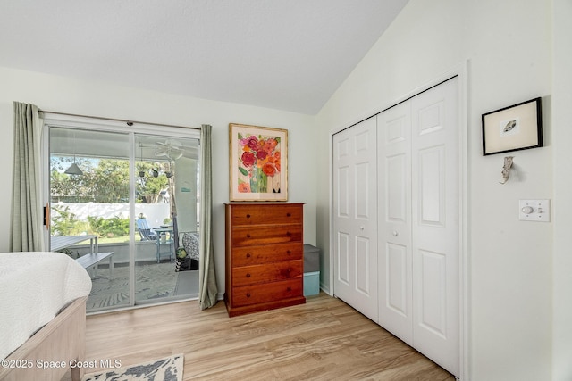 bedroom with light wood-style floors, access to outside, a closet, and lofted ceiling