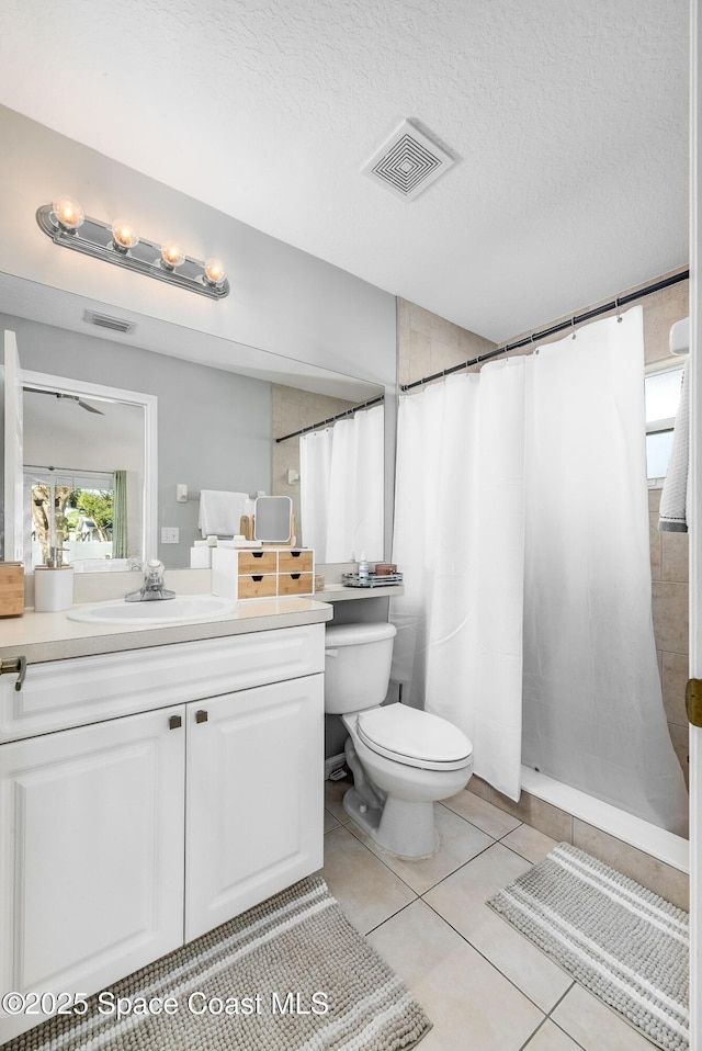 full bath featuring a textured ceiling, vanity, visible vents, and tile patterned floors