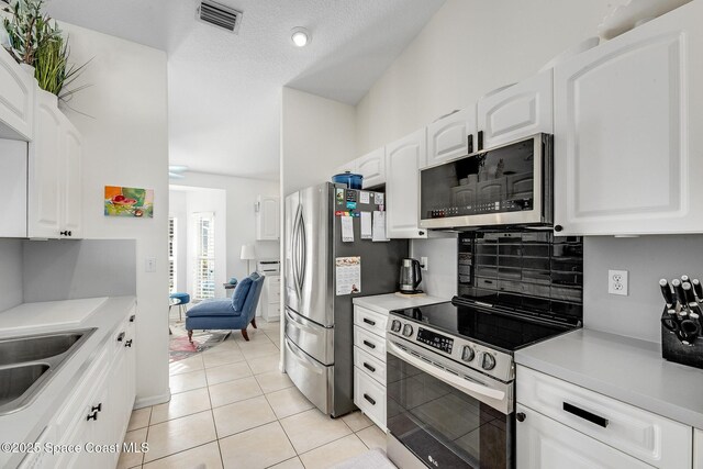 kitchen with white cabinetry, visible vents, appliances with stainless steel finishes, and light countertops