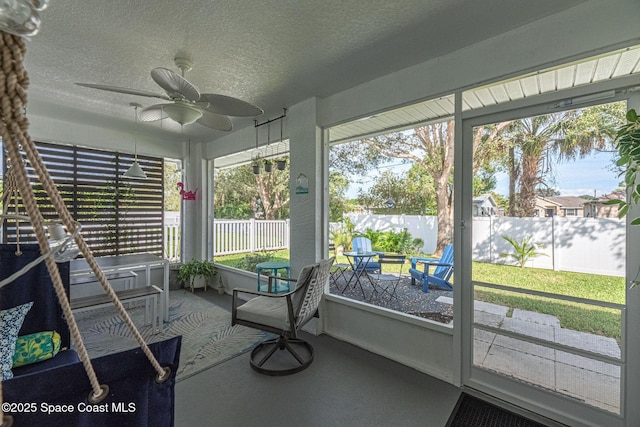 unfurnished sunroom featuring a wealth of natural light and a ceiling fan
