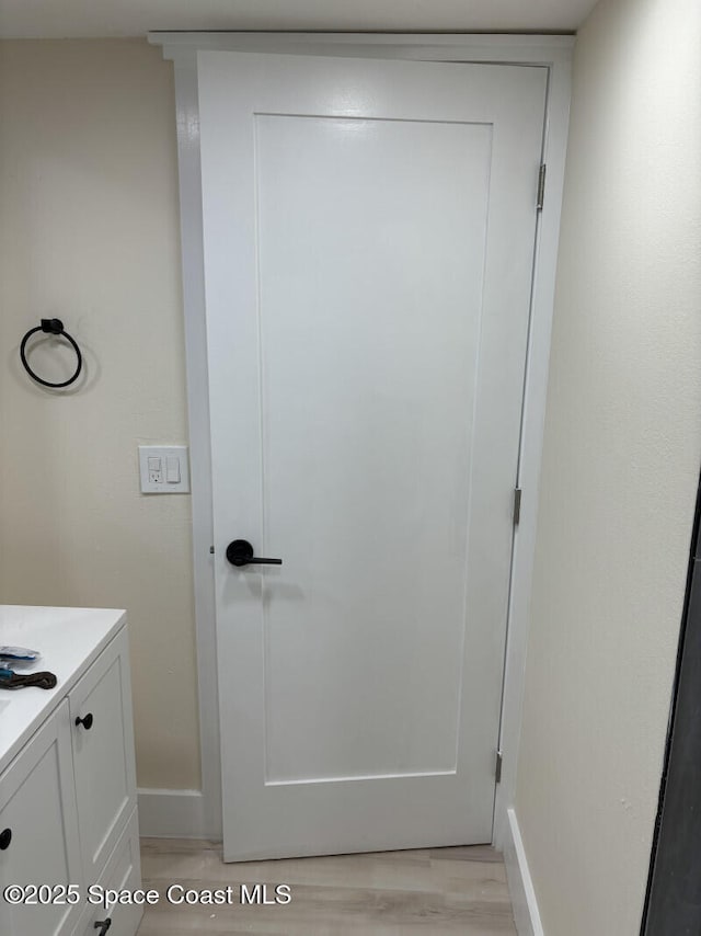 bathroom with wood finished floors, vanity, and baseboards