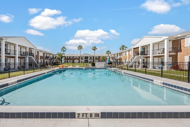 community pool featuring a residential view and fence