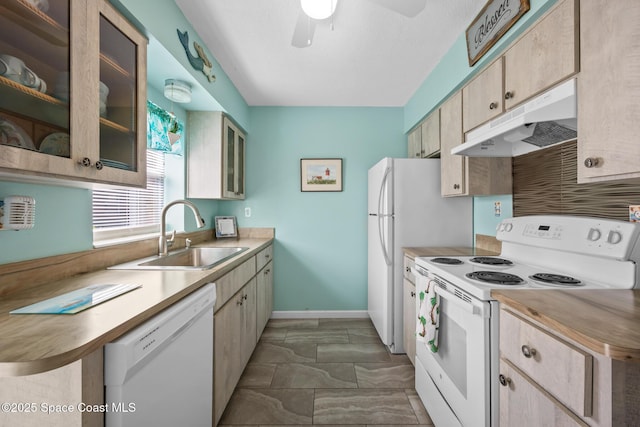 kitchen with glass insert cabinets, a sink, ceiling fan, white appliances, and under cabinet range hood