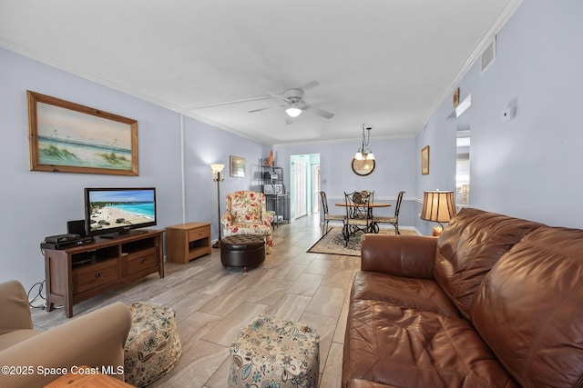 living room with ceiling fan, visible vents, and crown molding