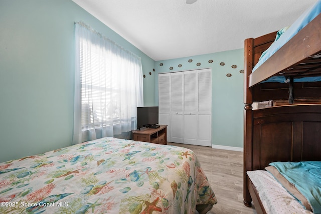 bedroom with a textured ceiling, a closet, and baseboards