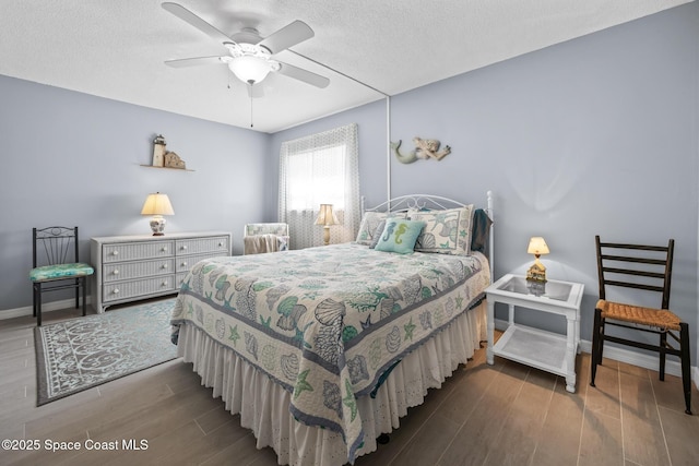 bedroom with a textured ceiling, wood finished floors, a ceiling fan, and baseboards