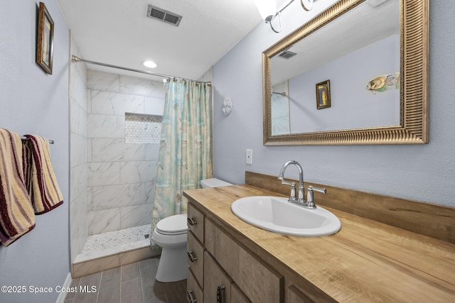 bathroom featuring visible vents, toilet, wood tiled floor, vanity, and tiled shower