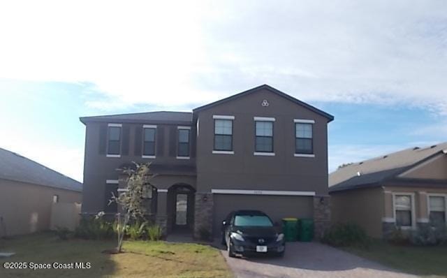 view of front facade featuring a garage, driveway, and stucco siding