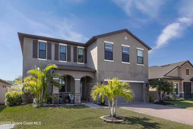 view of front facade featuring stone siding, stucco siding, driveway, and a garage