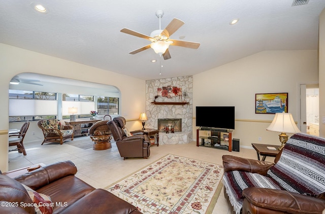 living room featuring light tile patterned floors, a ceiling fan, lofted ceiling, a stone fireplace, and recessed lighting