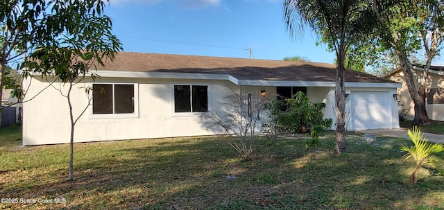 view of front facade with a front lawn, an attached garage, and stucco siding