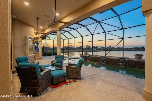 view of patio / terrace with ceiling fan, a water view, and a lanai