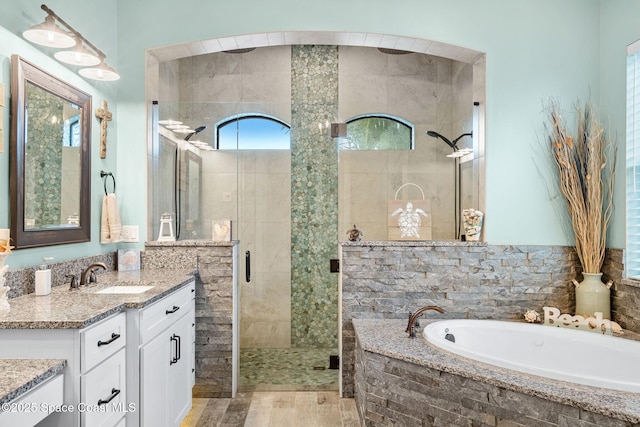 bathroom featuring a garden tub, a shower stall, and vanity