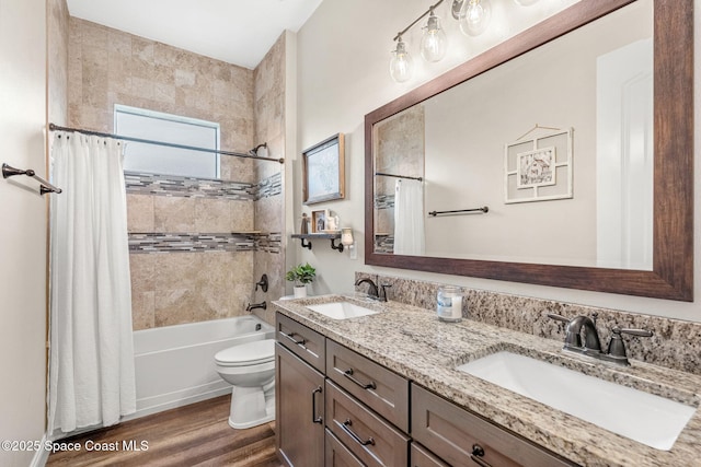 full bathroom featuring shower / tub combo, a sink, toilet, and wood finished floors