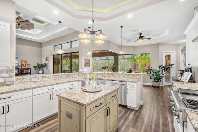 kitchen with range, dishwasher, dark wood-type flooring, a tray ceiling, and crown molding