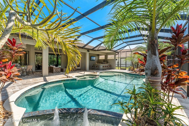 view of pool featuring outdoor dry bar, glass enclosure, a patio area, and a pool with connected hot tub