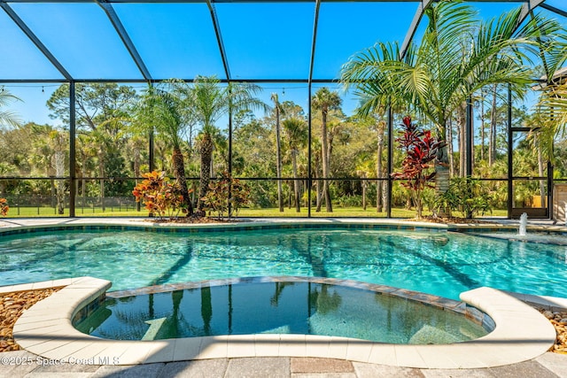 view of swimming pool featuring a lanai and a pool with connected hot tub