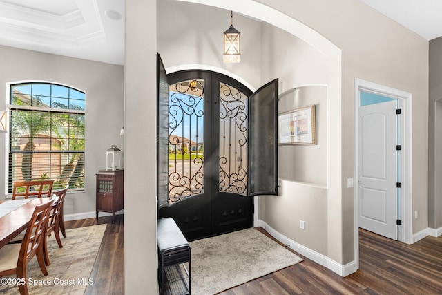 entryway featuring arched walkways, french doors, wood finished floors, and baseboards