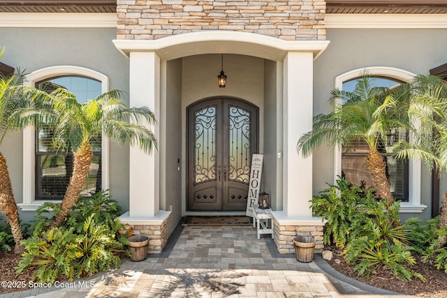 entrance to property with stone siding and stucco siding