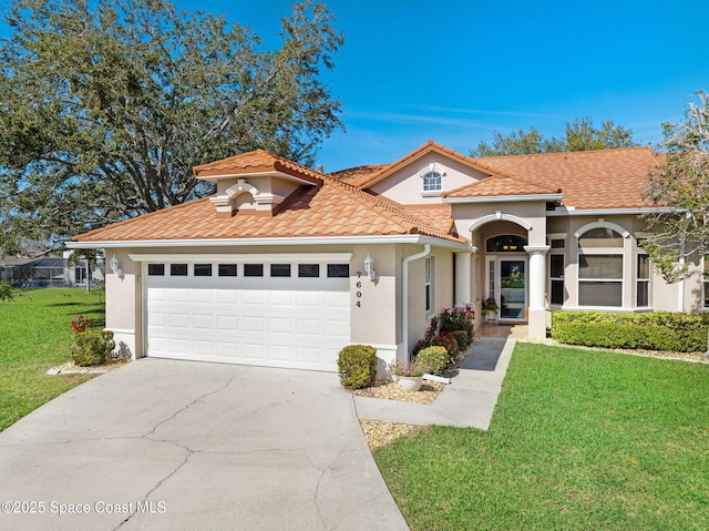 mediterranean / spanish-style home with driveway, a tile roof, an attached garage, a front lawn, and stucco siding