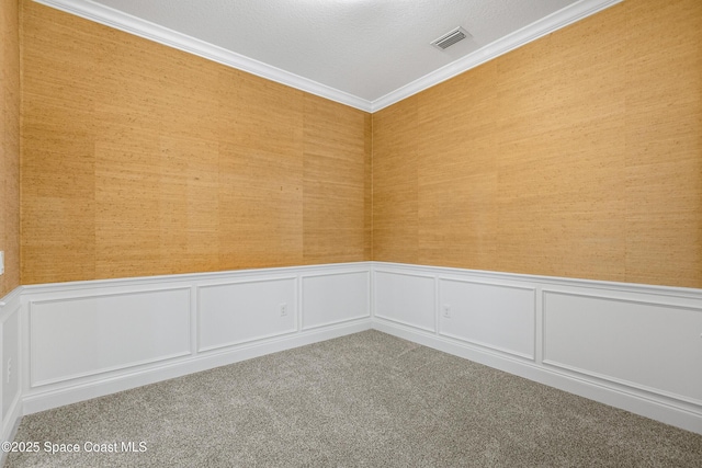 unfurnished room featuring visible vents, ornamental molding, wainscoting, carpet flooring, and wallpapered walls