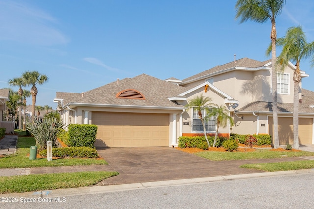 view of front of home with a garage, driveway, a shingled roof, and stucco siding