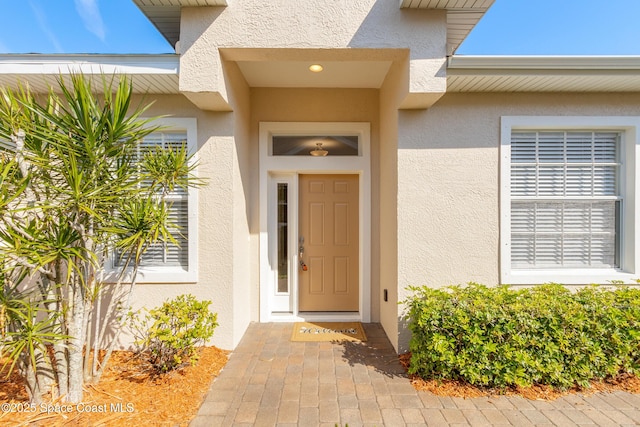 entrance to property featuring stucco siding