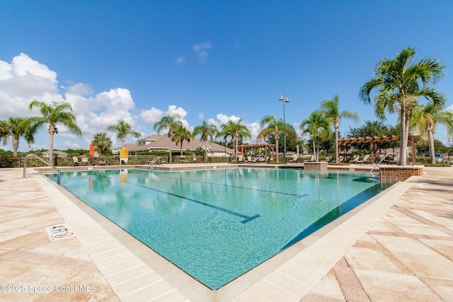 community pool with a patio area and a pergola