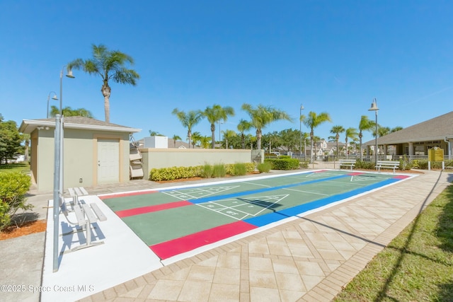 view of community featuring shuffleboard and fence