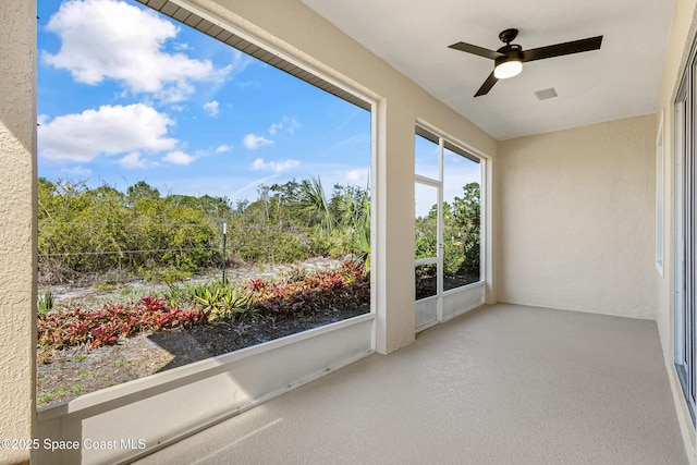 unfurnished sunroom featuring a ceiling fan and visible vents